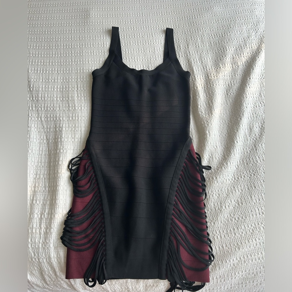 Bandage Marciano dress in size small and in black with fringes on the sides.